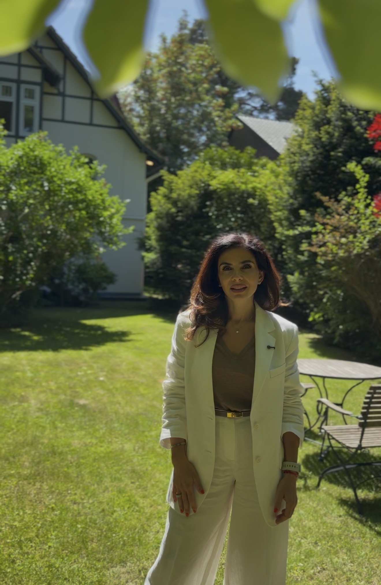 Elina Sapiro im Garten einer hochwertigen Immobilie